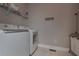 Bright laundry room featuring a modern washer and dryer with overhead shelving at 108 Jasmine Way, Villa Rica, GA 30180