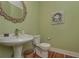 Charming powder room with pedestal sink, decorative mirror and wood flooring at 108 Jasmine Way, Villa Rica, GA 30180