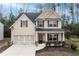 Inviting two-story home with manicured landscaping and a cozy front porch at 1558 Autumn Wood Trl, Sugar Hill, GA 30518