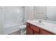 Bathroom features a tub/shower combo, tile floors, and cherry vanity at 1558 Autumn Wood Trl, Sugar Hill, GA 30518