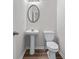 Bathroom featuring pedestal sink, updated toilet, and oval mirror at 1558 Autumn Wood Trl, Sugar Hill, GA 30518