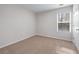 Neutral bedroom features carpet, large window allowing lots of natural light, and crisp trim work at 1558 Autumn Wood Trl, Sugar Hill, GA 30518