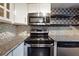 Beautiful kitchen featuring stainless steel appliances, mosaic backsplash, and granite countertops at 290 Lakemoore Ne Dr # C, Atlanta, GA 30342