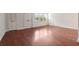 Vacant living room with hardwood floors, bright windows, and entry to kitchen at 290 Lakemoore Ne Dr # C, Atlanta, GA 30342
