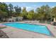 Outdoor pool with blue water surrounded by lounge chairs, tables, and greenery at 290 Lakemoore Ne Dr # C, Atlanta, GA 30342