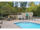 Outdoor pool with tables, chairs, and lush trees in the background at 290 Lakemoore Ne Dr # C, Atlanta, GA 30342