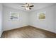 A well-lit bedroom with two windows and a ceiling fan, featuring hardwood floors and white walls at 1506 Sycamore Nw Dr, Kennesaw, GA 30152