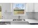 A close-up of a kitchen sink with a view of the backyard through the window at 1506 Sycamore Nw Dr, Kennesaw, GA 30152