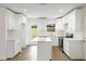 Bright white kitchen featuring modern appliances, quartz countertops, island, and hardwood floors at 1506 Sycamore Nw Dr, Kennesaw, GA 30152