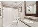 Bathroom with granite countertop vanity, decorative mirror, and shower with tub at 220 Renaissance Ne Pkwy # 1205, Atlanta, GA 30308