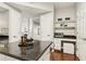 Kitchen island with granite countertop, seating, and storage near an integrated desk at 220 Renaissance Ne Pkwy # 1205, Atlanta, GA 30308