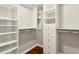 Spacious walk-in closet with custom shelves, drawers, and wooden floor at 220 Renaissance Ne Pkwy # 1205, Atlanta, GA 30308