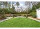 Lush green lawn surrounded by mature trees and stone retaining walls offers a serene outdoor space at 2374 Havenridge Nw Dr, Atlanta, GA 30305