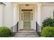 The home's entrance has stately columns, a painted front door, and wrought iron railings, providing a welcoming feel at 2374 Havenridge Nw Dr, Atlanta, GA 30305