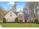 Charming two-story home with manicured lawn, a red door, and a mix of stone and siding accents at 4910 Hunters Oaks Ln, Alpharetta, GA 30009