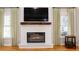 Beautiful fireplace with a white mantel, a mounted TV, and a dark wood accent at 4910 Hunters Oaks Ln, Alpharetta, GA 30009