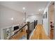 Hallway features hardwood floors, iron railings, and a view of the living room below at 4910 Hunters Oaks Ln, Alpharetta, GA 30009