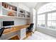 Well-lit home office with built-in shelving, a spacious desk, hardwood floors, and a large window at 4910 Hunters Oaks Ln, Alpharetta, GA 30009