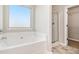 Bright bathroom featuring a soaking tub, glass shower, and closet at 244 Magnaview Dr, Mcdonough, GA 30253