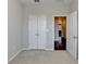 Bedroom with double closet doors offers ample storage space with carpeted floors and neutral paint for a cozy feel at 4498 Dunblane Ave, Sugar Hill, GA 30518