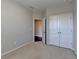 Bedroom with double closet doors offers ample storage space with carpeted floors and neutral paint for a cozy feel at 4498 Dunblane Ave, Sugar Hill, GA 30518