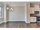 Dining room with hardwood floors, neutral walls, and a modern chandelier next to the kitchen at 4498 Dunblane Ave, Sugar Hill, GA 30518