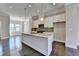 Bright kitchen with stainless steel appliances, granite countertops, and a large island with a sink and faucet at 4498 Dunblane Ave, Sugar Hill, GA 30518