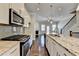 Modern kitchen features stainless steel appliances, granite countertops, and a kitchen island with a sink and faucet at 4498 Dunblane Ave, Sugar Hill, GA 30518