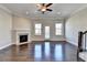 Bright living room with a fireplace, ceiling fan, and beautiful hardwood floors at 4498 Dunblane Ave, Sugar Hill, GA 30518
