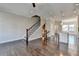 Open concept living room leading to the kitchen featuring hardwood floors and a staircase with iron spindles at 4498 Dunblane Ave, Sugar Hill, GA 30518