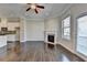 Living room featuring hardwood floors, a fireplace and an open concept kitchen with white cabinetry at 4498 Dunblane Ave, Sugar Hill, GA 30518
