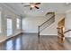 Open living room featuring hardwood floors, staircase with iron spindles, and neutral wall paint at 4498 Dunblane Ave, Sugar Hill, GA 30518