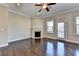 Living room featuring a fireplace, ceiling fan, and access to an outdoor balcony through glass doors at 4498 Dunblane Ave, Sugar Hill, GA 30518