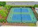 Aerial view of two well-maintained tennis courts, set within a landscaped community at 4498 Dunblane Ave, Sugar Hill, GA 30518
