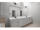 A bathroom featuring double sinks with a large mirror, complemented by elegant fixtures and ample cabinet space at 628 Avondale Hills Dr, Decatur, GA 30032