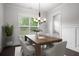 Bright dining room with hardwood floors, natural light, wainscoting, modern chandelier, and seating for six at 628 Avondale Hills Dr, Decatur, GA 30032