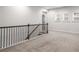 Upstairs hallway with neutral carpet and wrought iron railing, creating an open transition space at 628 Avondale Hills Dr, Decatur, GA 30032
