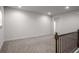 Upstairs hallway with neutral carpet and wrought iron railing, providing an open transition to other rooms at 628 Avondale Hills Dr, Decatur, GA 30032