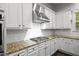 Kitchen with white cabinets, a stainless steel range hood, and granite counters at 628 Avondale Hills Dr, Decatur, GA 30032