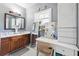 Well-lit bathroom with double vanities, makeup table, cabinets, and a large window bringing in natural light at 1369 Sierra Ridge Pl, Loganville, GA 30052