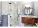Modern bathroom featuring a glass-enclosed shower with mosaic tile accents and a double vanity with granite countertop at 1369 Sierra Ridge Pl, Loganville, GA 30052