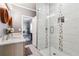 Bathroom showcasing a double vanity, a tiled shower, and a view into the bedroom at 1369 Sierra Ridge Pl, Loganville, GA 30052