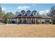 Charming brick home featuring dormer windows, a pillared porch, and manicured landscaping at 1369 Sierra Ridge Pl, Loganville, GA 30052