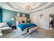 A primary bedroom features a tufted headboard, tray ceilings, and a cozy sitting area with lots of light at 1369 Sierra Ridge Pl, Loganville, GA 30052