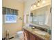 This bathroom features a granite countertop, bronze fixtures, and white cabinetry at 2520 Cross Springs Dr, Cumming, GA 30041