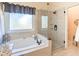 This main bathroom features a glass enclosed shower and a soaking tub by the window at 2520 Cross Springs Dr, Cumming, GA 30041