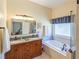 This main bathroom features double sinks, a soaking tub, and a separate glass enclosed shower at 2520 Cross Springs Dr, Cumming, GA 30041