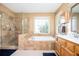 Bright bathroom featuring a large soaking tub, a separate glass shower, and a double vanity at 1439 Evers Pl, Lawrenceville, GA 30043