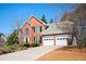 Charming two-story red brick home featuring a two-car garage and well-manicured landscaping at 1439 Evers Pl, Lawrenceville, GA 30043