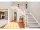 Bright foyer featuring hardwood floors, a staircase with white railings, and a view into the living room at 1439 Evers Pl, Lawrenceville, GA 30043